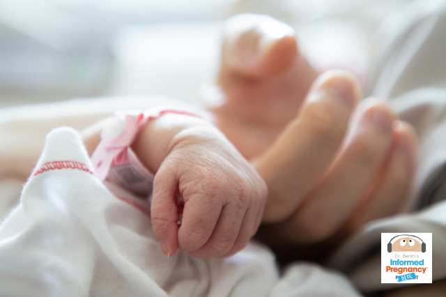 Infant hand with hospital identification bracelet holds adults finger.