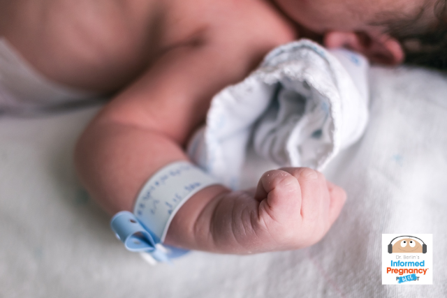 Infant with balled fist and hospital identification bracelet.
