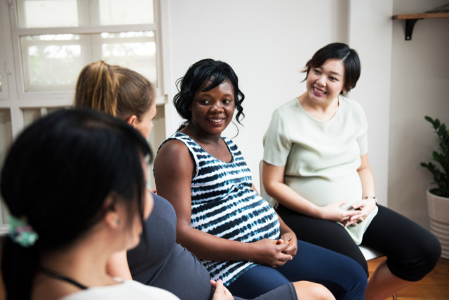 Pregnant omen sitting in a group labor prep class